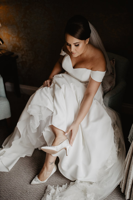 Getting into a wedding dress, at Clanard Court Hotel, Athy, Co. Kildare by wedding photographer Mario Vaitkus