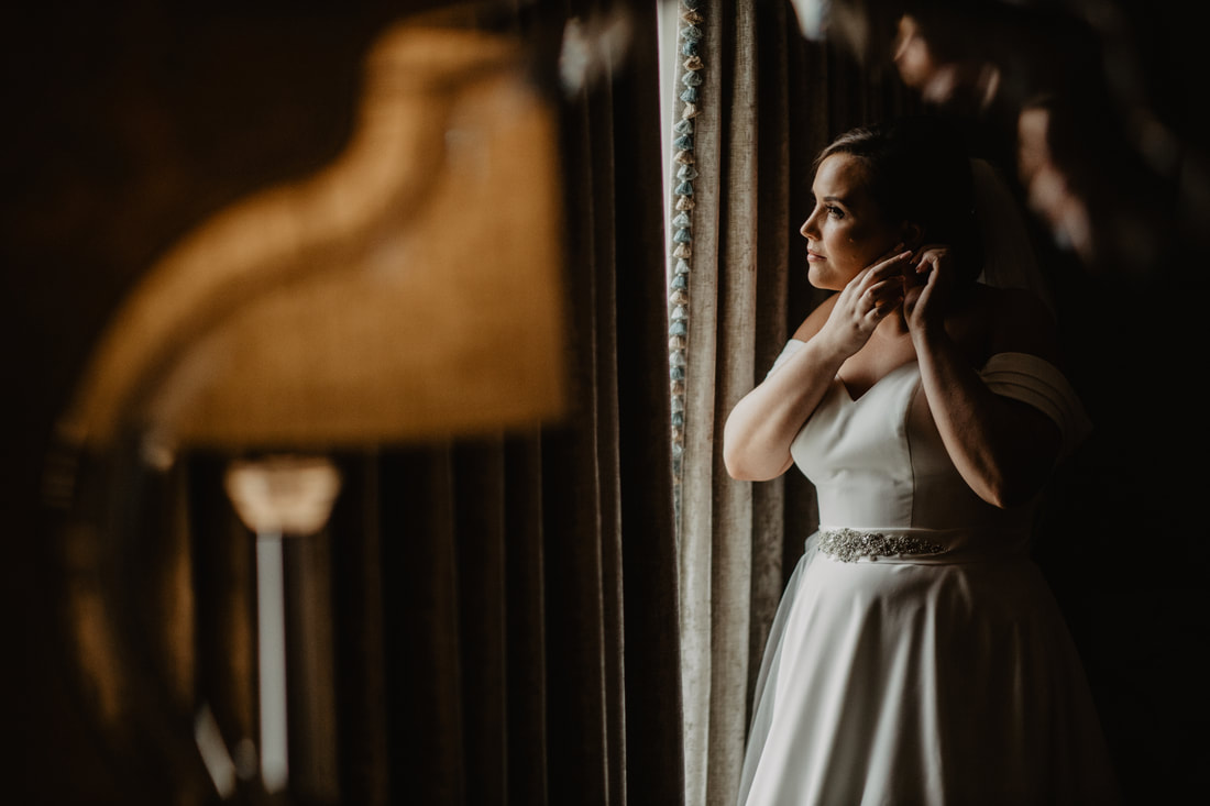 Bride in front of the window at Clanard Court Hotel, Athy, Co. Kildare by wedding photographer Mario Vaitkus