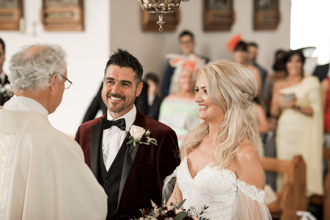 Bride and groom greets priest in a wedding in Carlingford