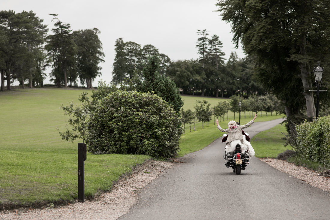 Bride and groom on a bike at Darver Castle