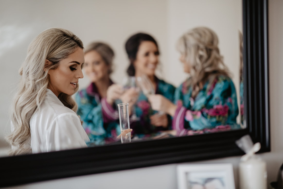 Bride and bridesmaids reflection in the mirror