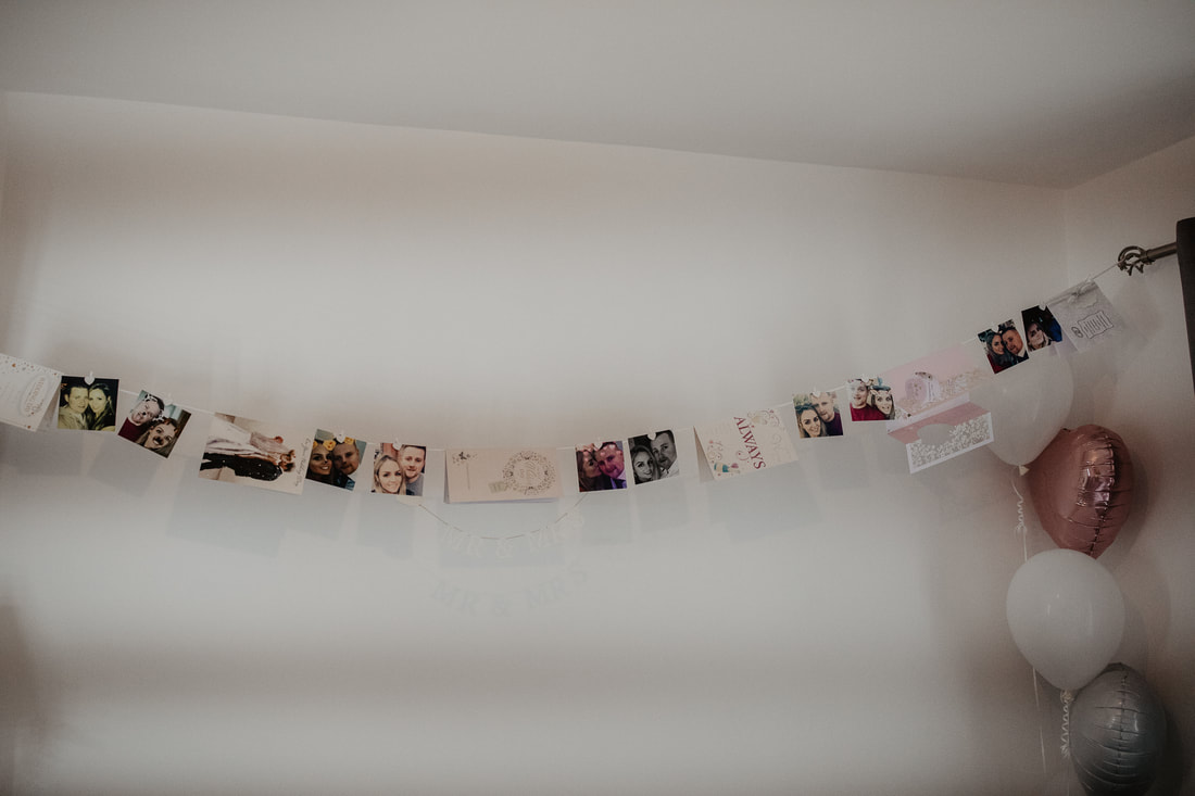 Little wedding decor, with personal photos hanging on a wall in a morning. Photographer www.mariovaitkus.ie