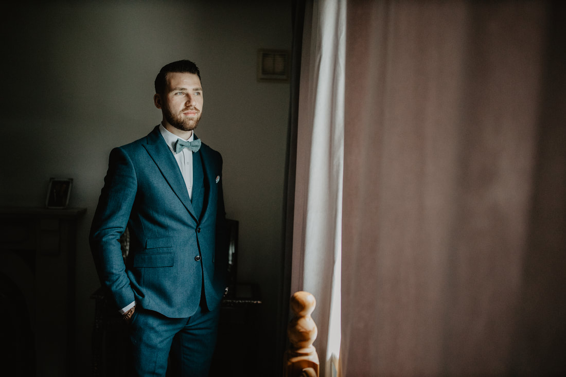 Groom at a window before he gets married