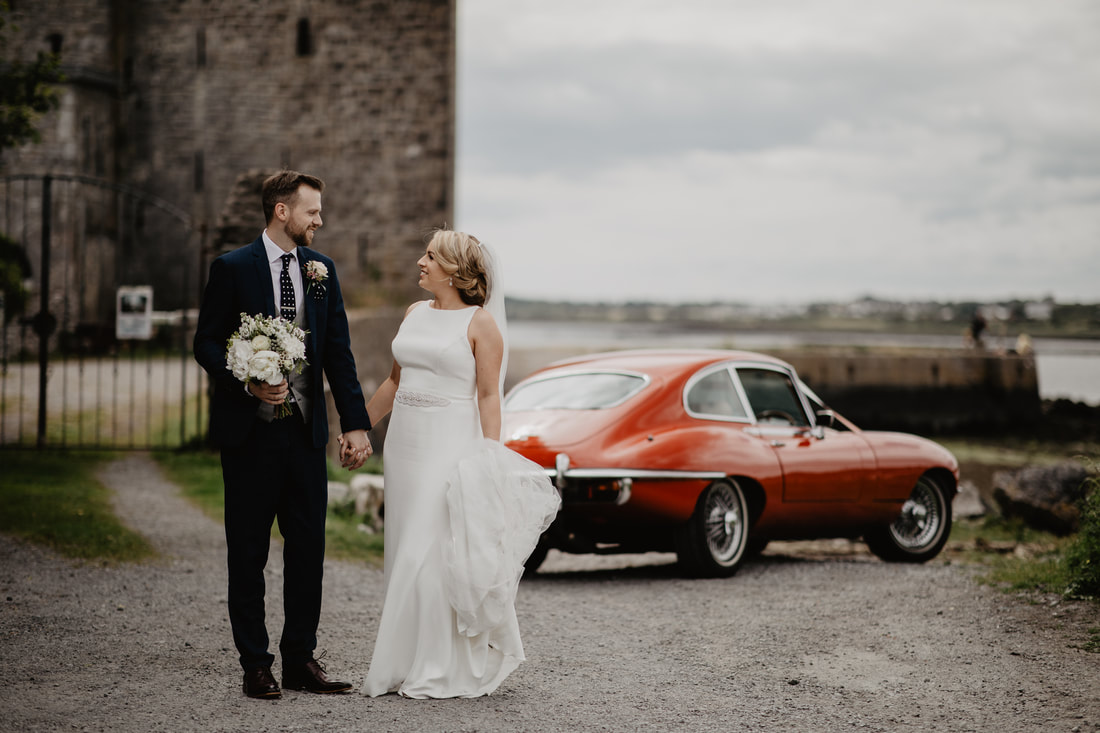 Bride and groom at a castle on a shore at Atlantic ocean in Galway